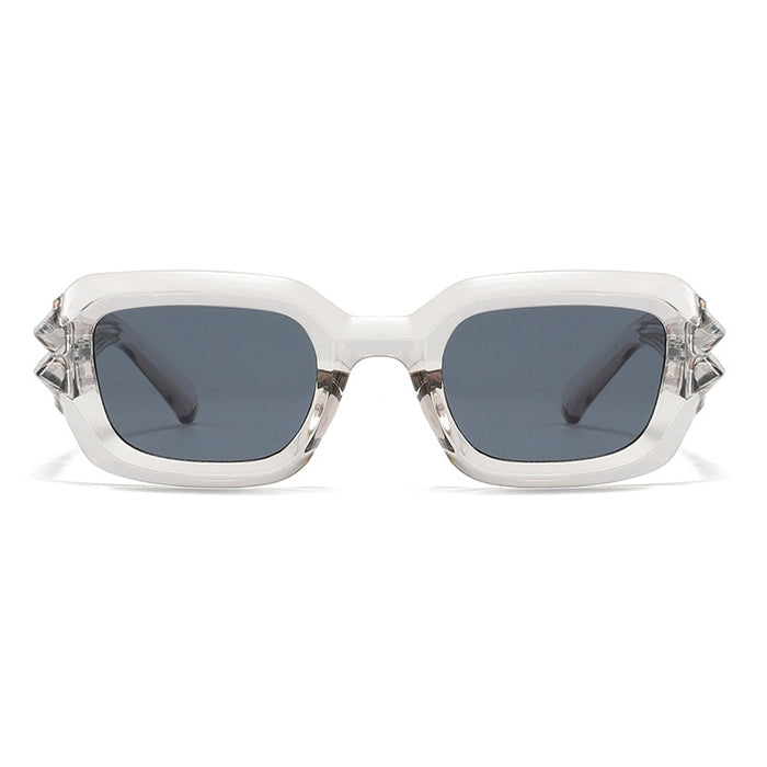 Transparent, thick-rimmed sunglasses featuring a rectangular frame design, fitted with dark gray lenses, and accented with angular detailing at the temples.