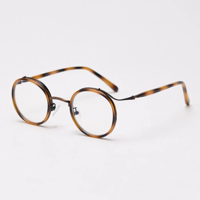 Round-framed glasses featuring a tortoiseshell pattern, with slender, antique-bronze-colored wavy metal detailing at the frame joints.