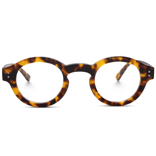 A front view of round, tortoiseshell-patterned eyeglasses, featuring a thick acetate frame design accented with decorative metal rivets at the edges.