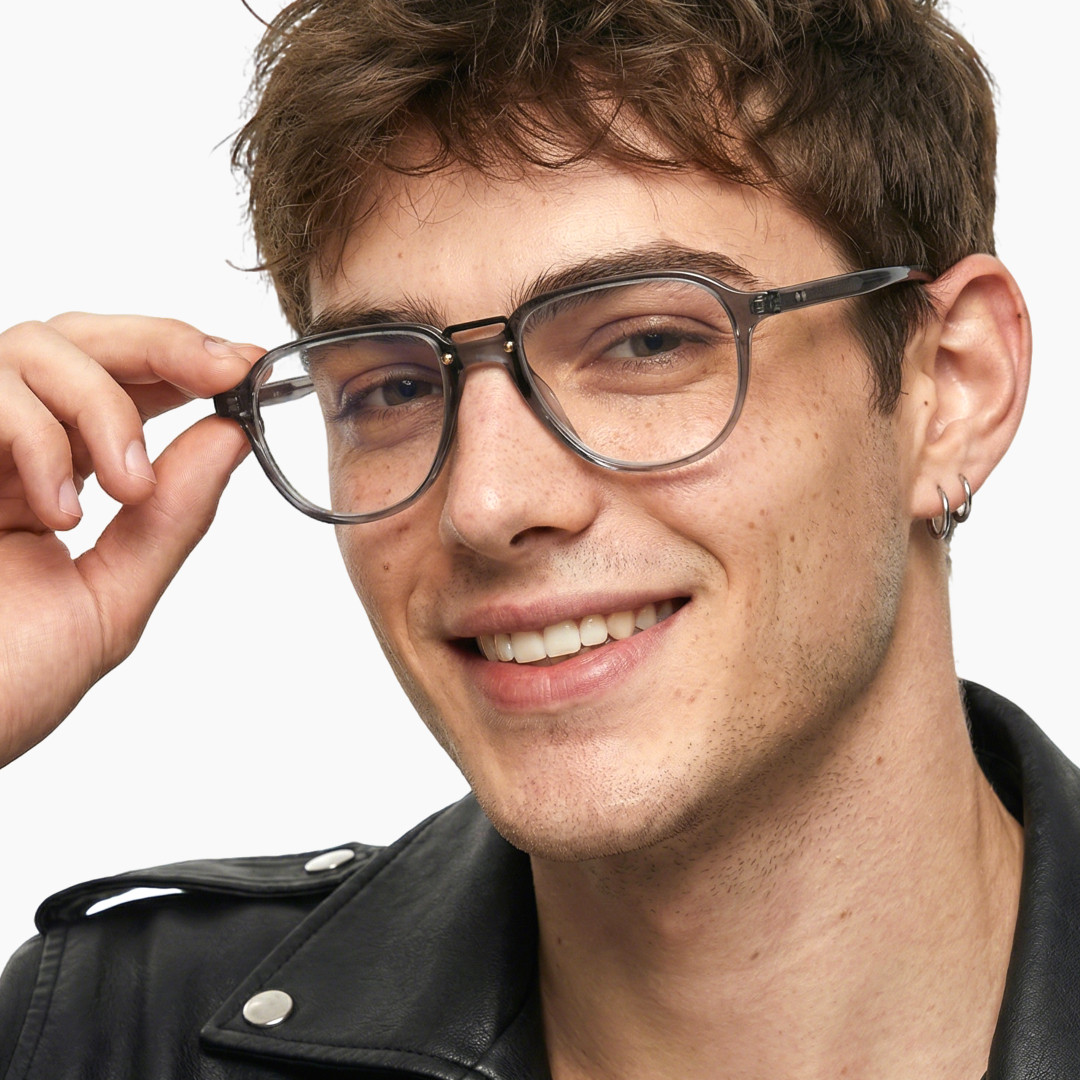 Close-up view of male wearing grey aviator eyeglasses, touching frame, smiling, AA0062306