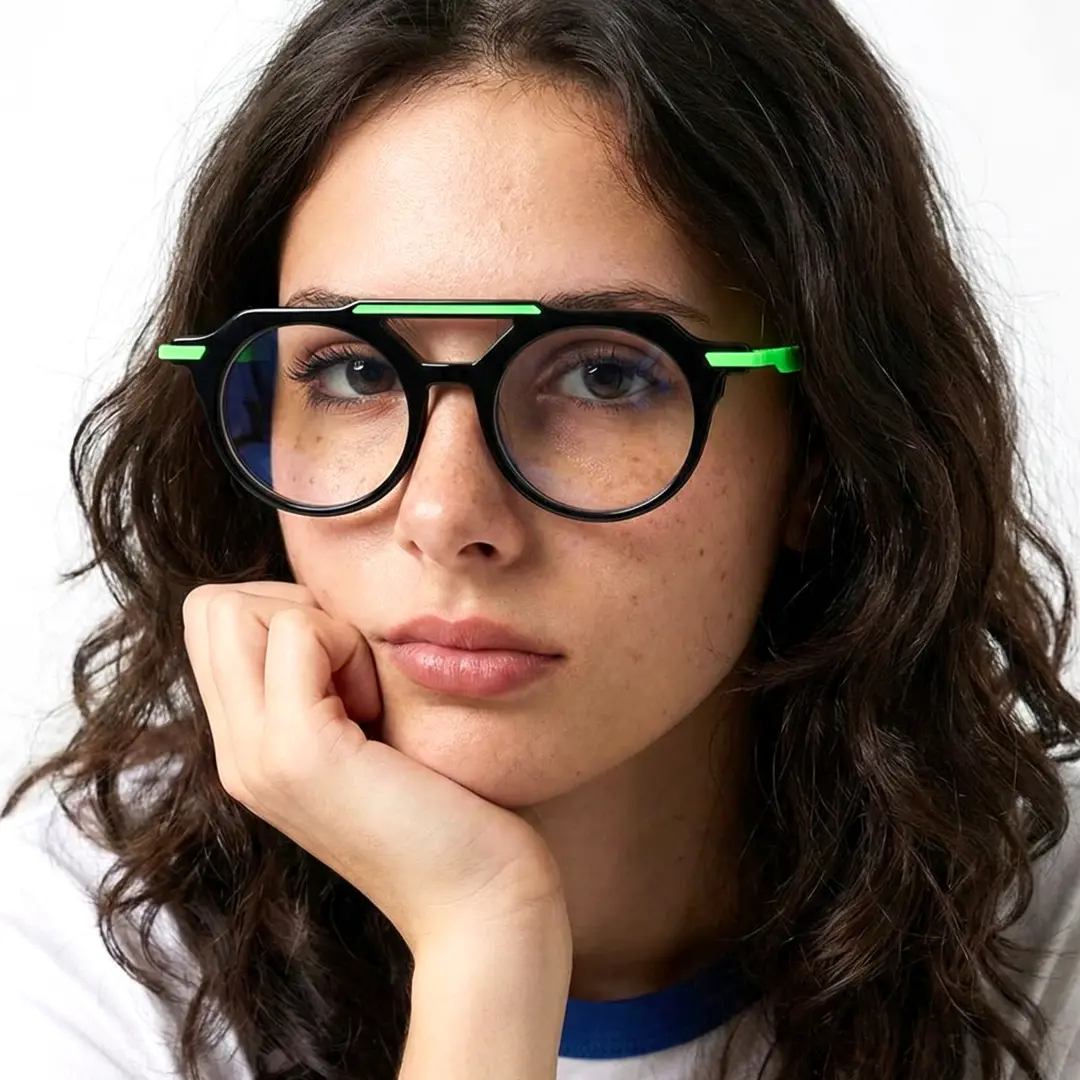 Looking straight ahead view of female wearing black aviator eyeglasses, resting chin on hand, natural expression, AA0082302