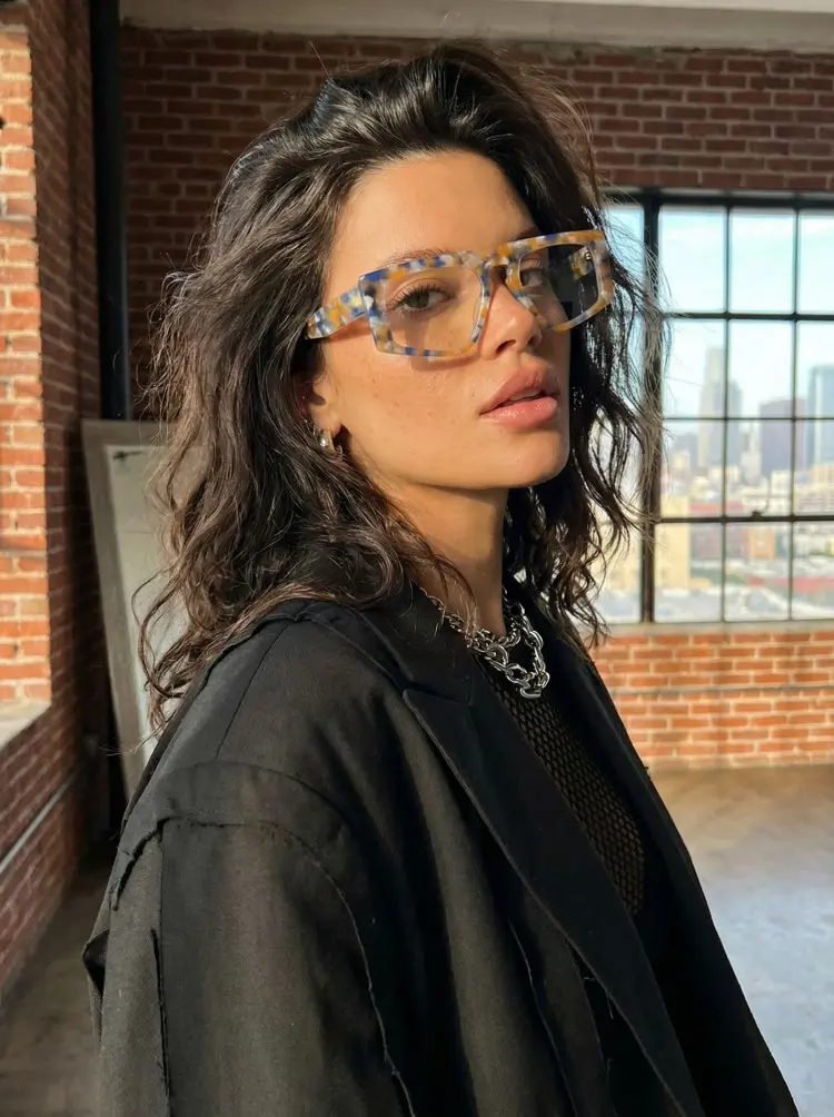 Female model wearing vintage yellow tortoise aviator acetate eyeglasses in a loft with brick walls and city view. SPU: AA0122403