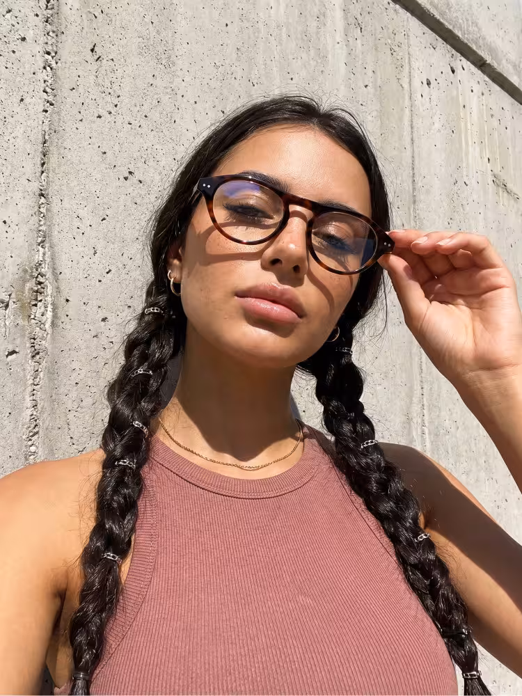Female model wearing vintage tortoise aviator acetate eyeglasses against a sunlit concrete wall. SPU: AA0222603