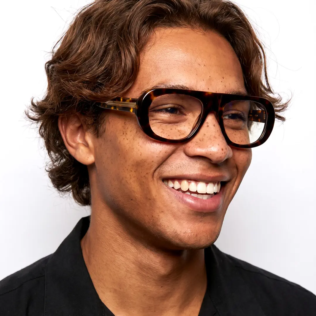 Three-quarter view of male wearing vintage tortoise aviator eyeglasses, smiling, AA0242604