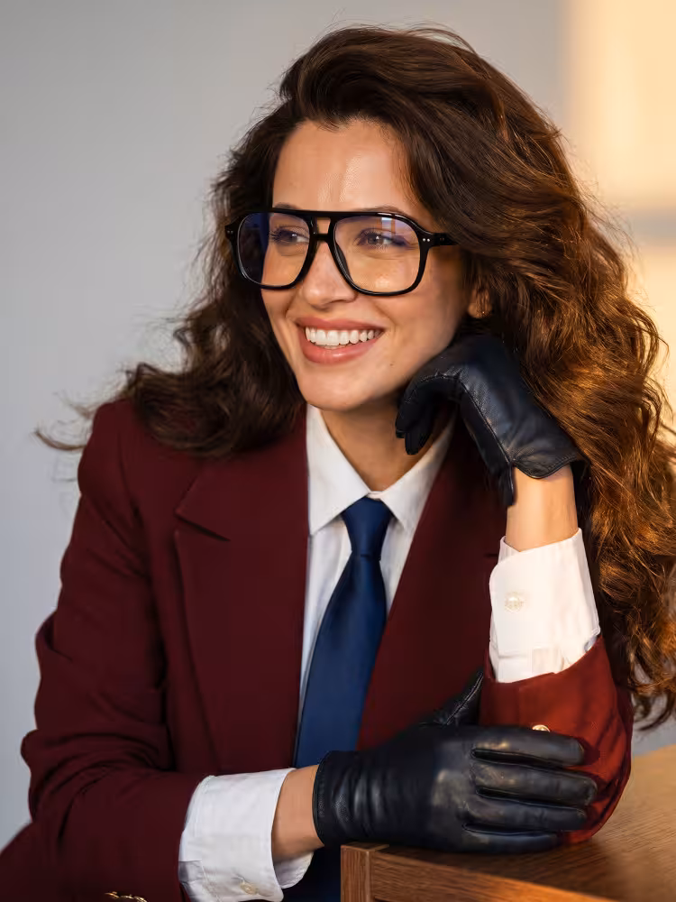 Female model wearing vintage gold aviator acetate eyeglasses in an indoor portrait studio leaning on a wooden table . SPU: AA0322605