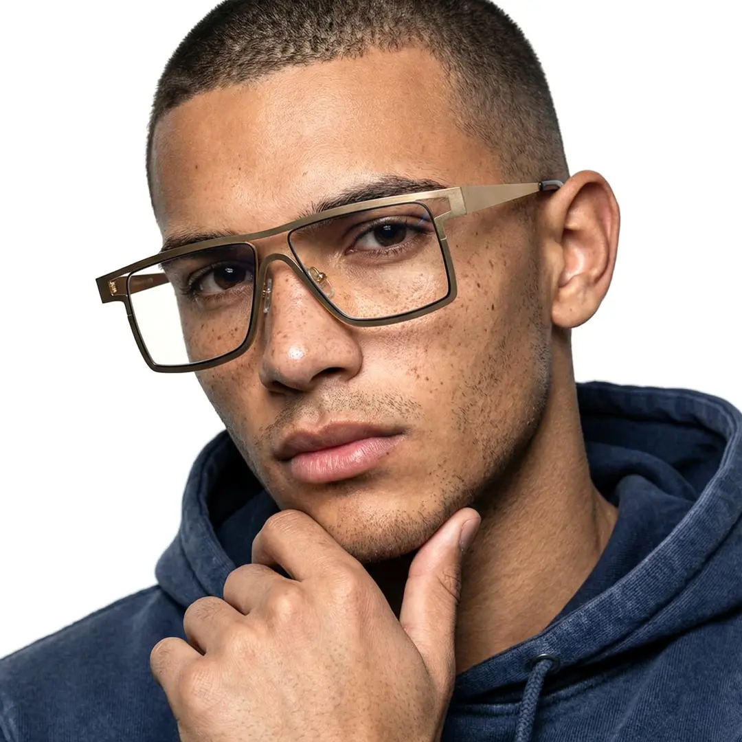 Profile view of male wearing gold aviator eyeglasses, resting chin on hand, neutral expression, AM0092212