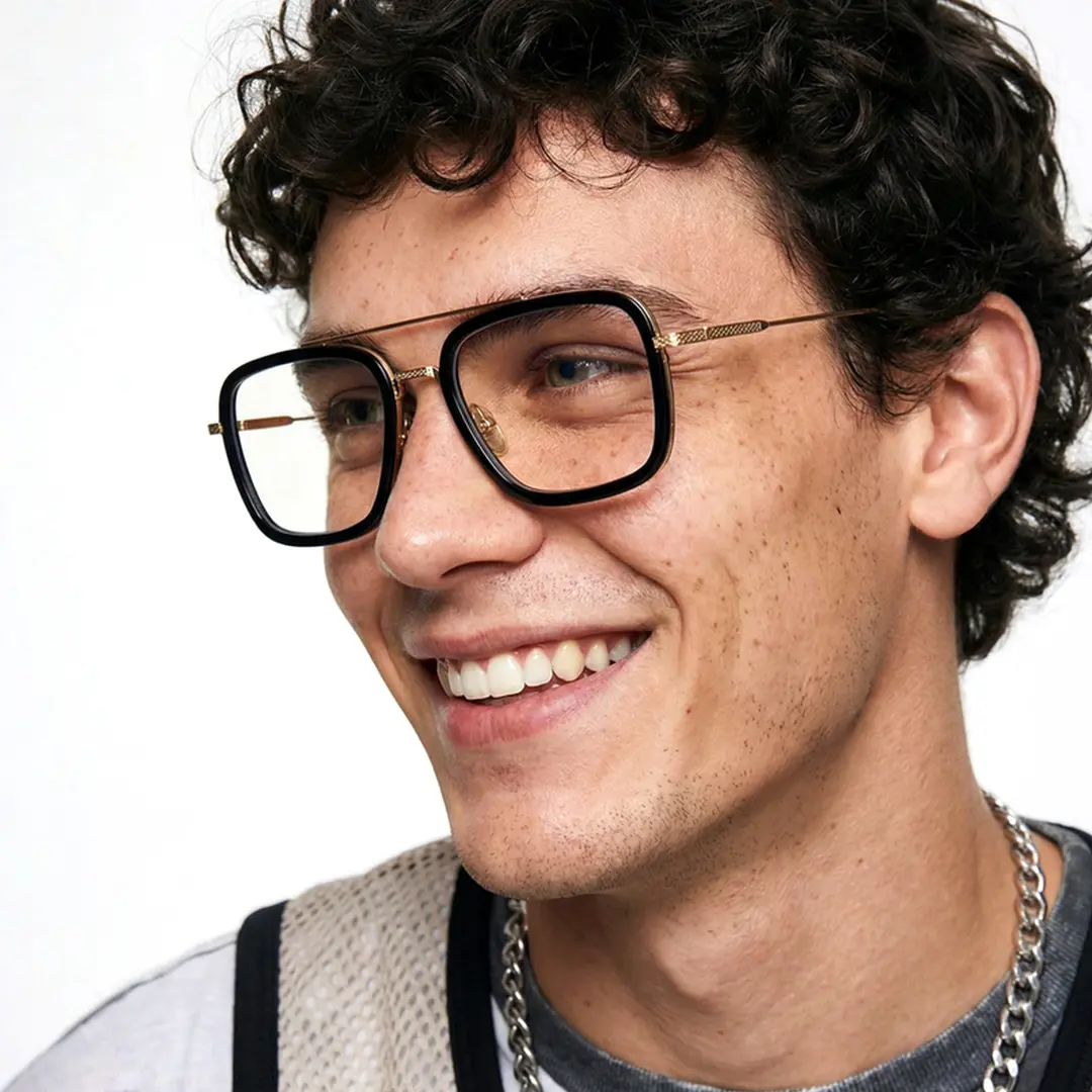 Full profile view of male wearing black gold aviator eyeglasses, natural smile, AM0222409