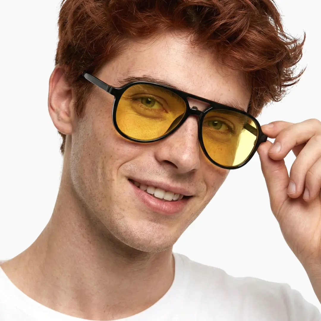 Tilted head view of male wearing black aviator magnetic clip-on eyeglasses set with interchangeable clip-on lenses, touching frame, smiling, AR0122601