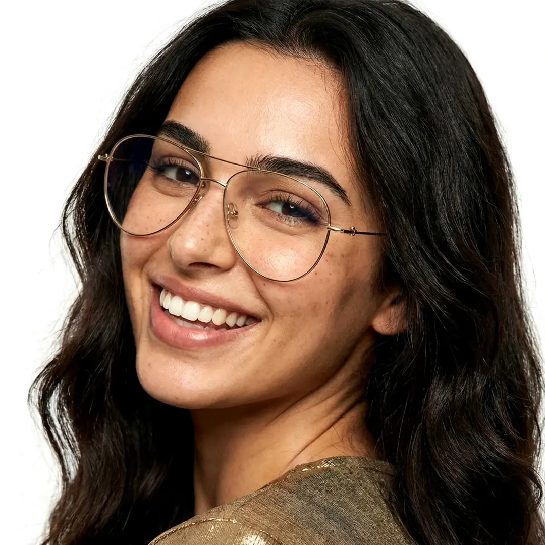 Tilted head view of female wearing gold aviator eyeglasses, smiling, AT0262601