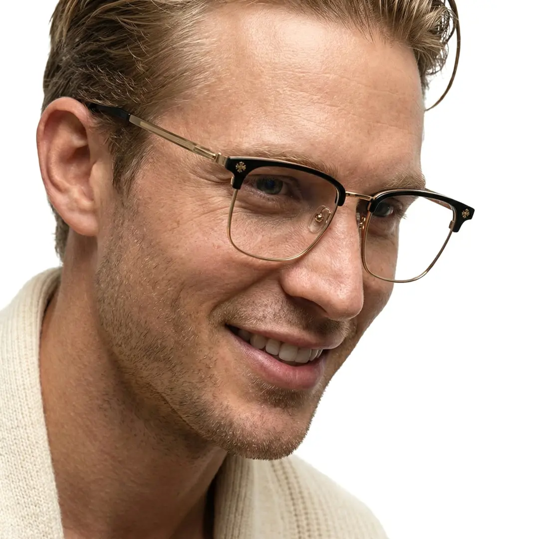 Looking away view of male wearing gold browline eyeglasses, soft smile, BM0112501