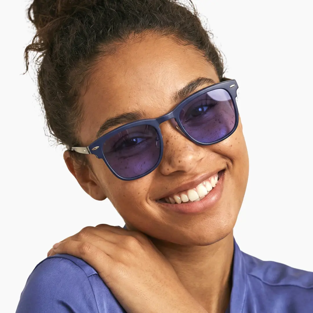 Three-quarter view of female wearing black browline magnetic clip-on eyeglasses set with purple clip-on lenses, tilting head, smiling, BR0102601