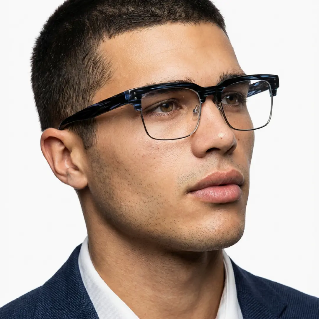Three-quarter view of male wearing blue tortoise browline eyeglasses, calm expression, BR0572505