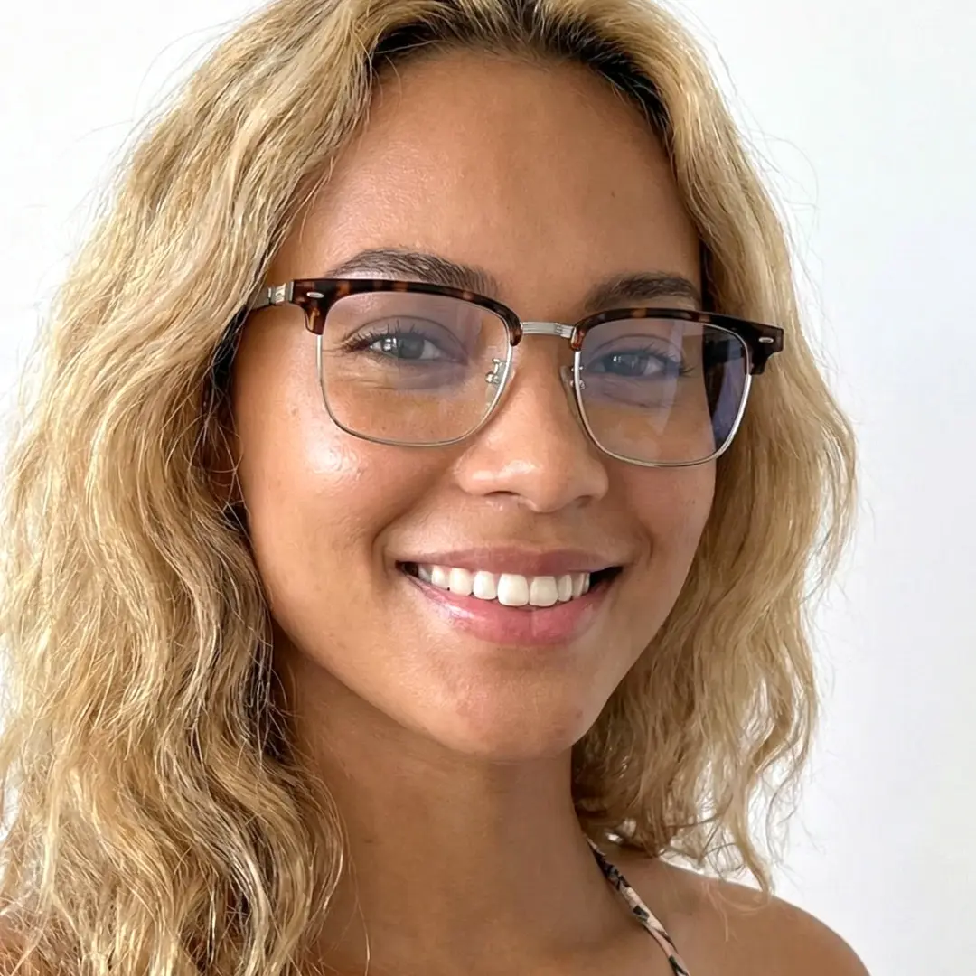 Slightly angled view of female wearing tortoise browline eyeglasses, natural smile, BX0402509