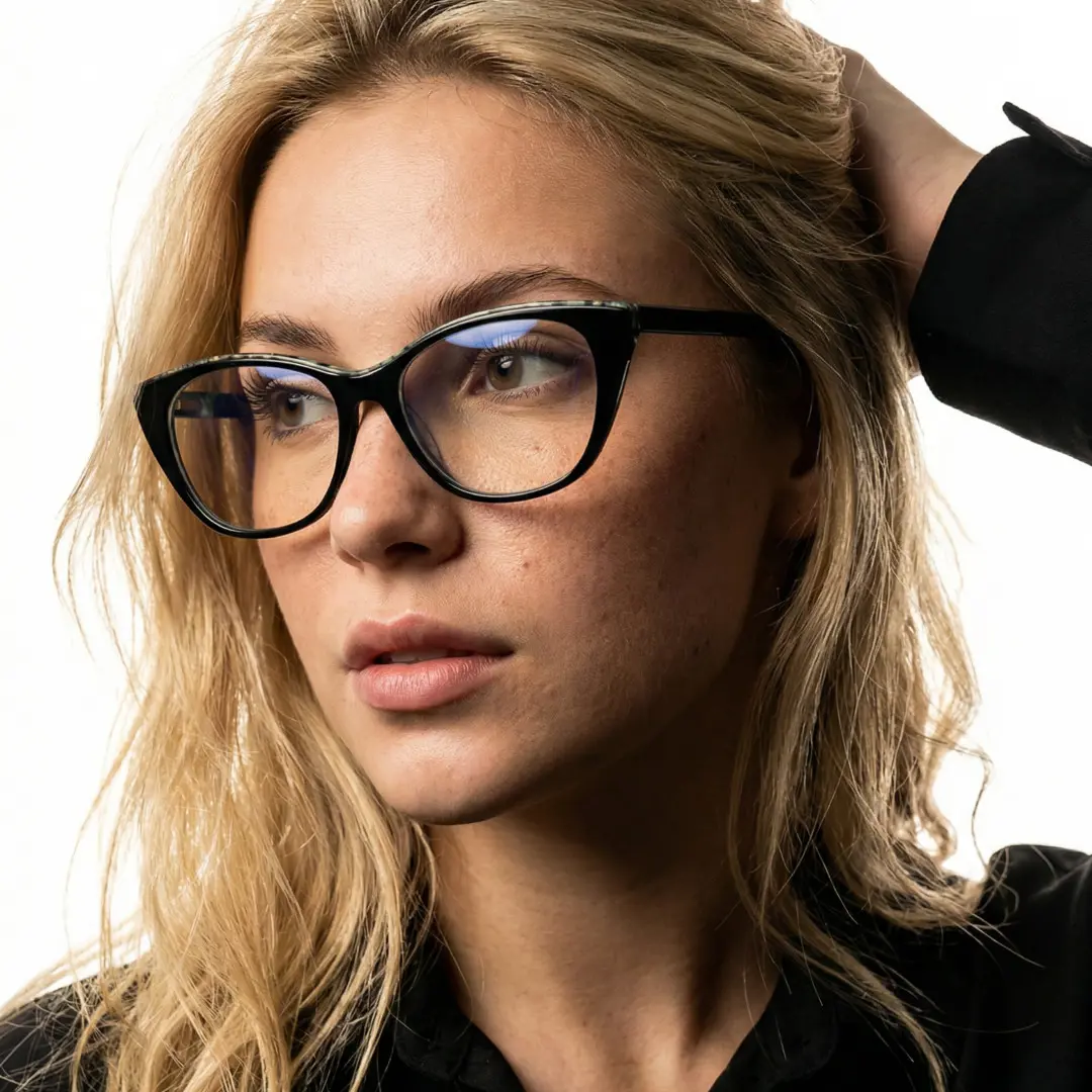 Three-quarter view of female wearing black cat eye eyeglasses, hand in hair, neutral expression, CA0012208