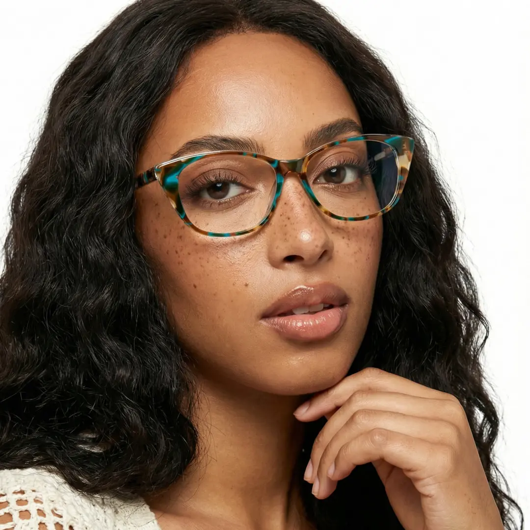 Three-quarter view of female wearing blue tortoise cat eye eyeglasses, finger on chin, neutral expression, CA0012208