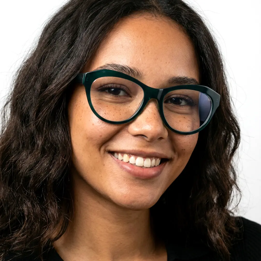 Slightly angled view of female wearing green cat eye eyeglasses, smiling, CA0032302