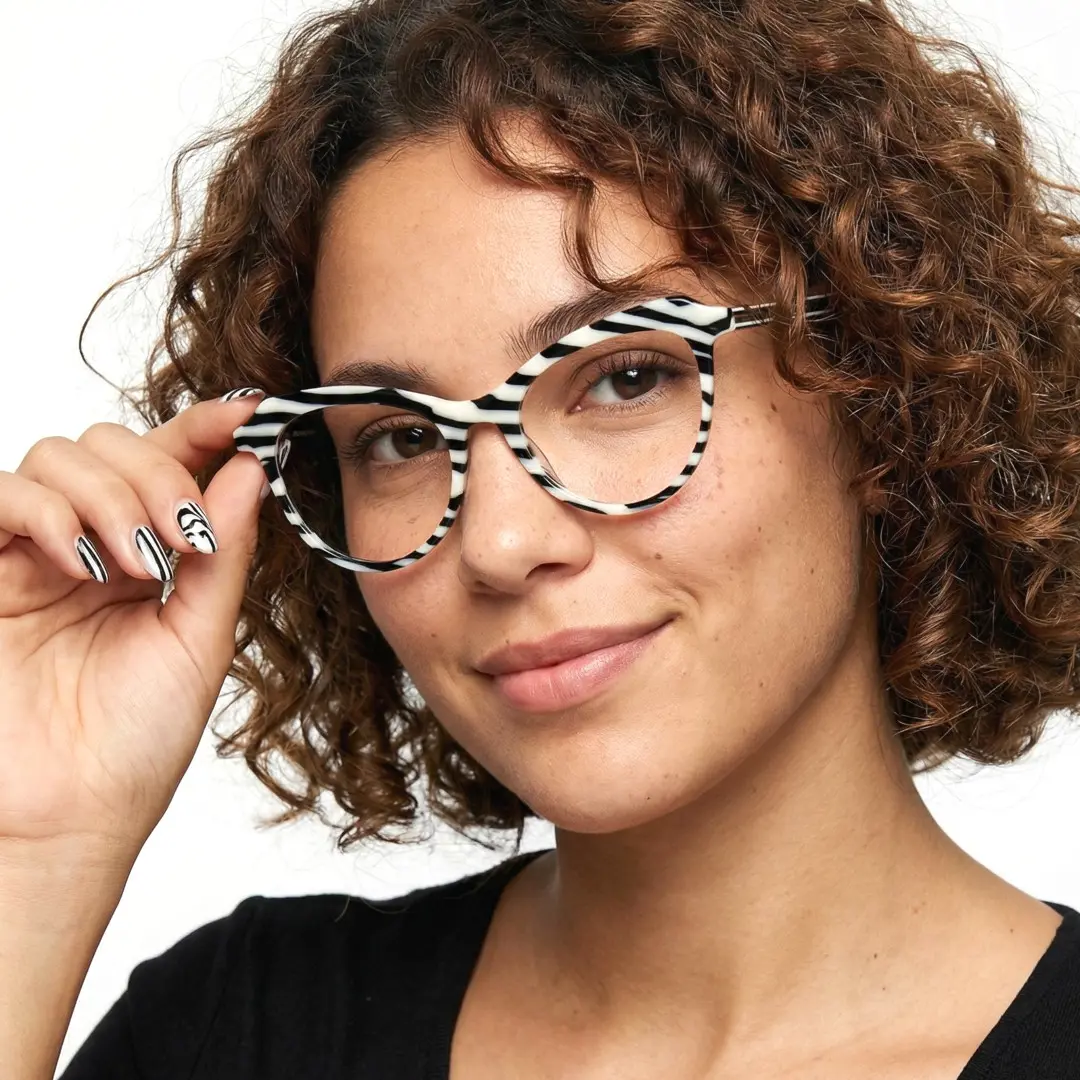 Slightly angled view of female wearing colorful black cat eye eyeglasses, holding glasses, natural smile, CA0092306