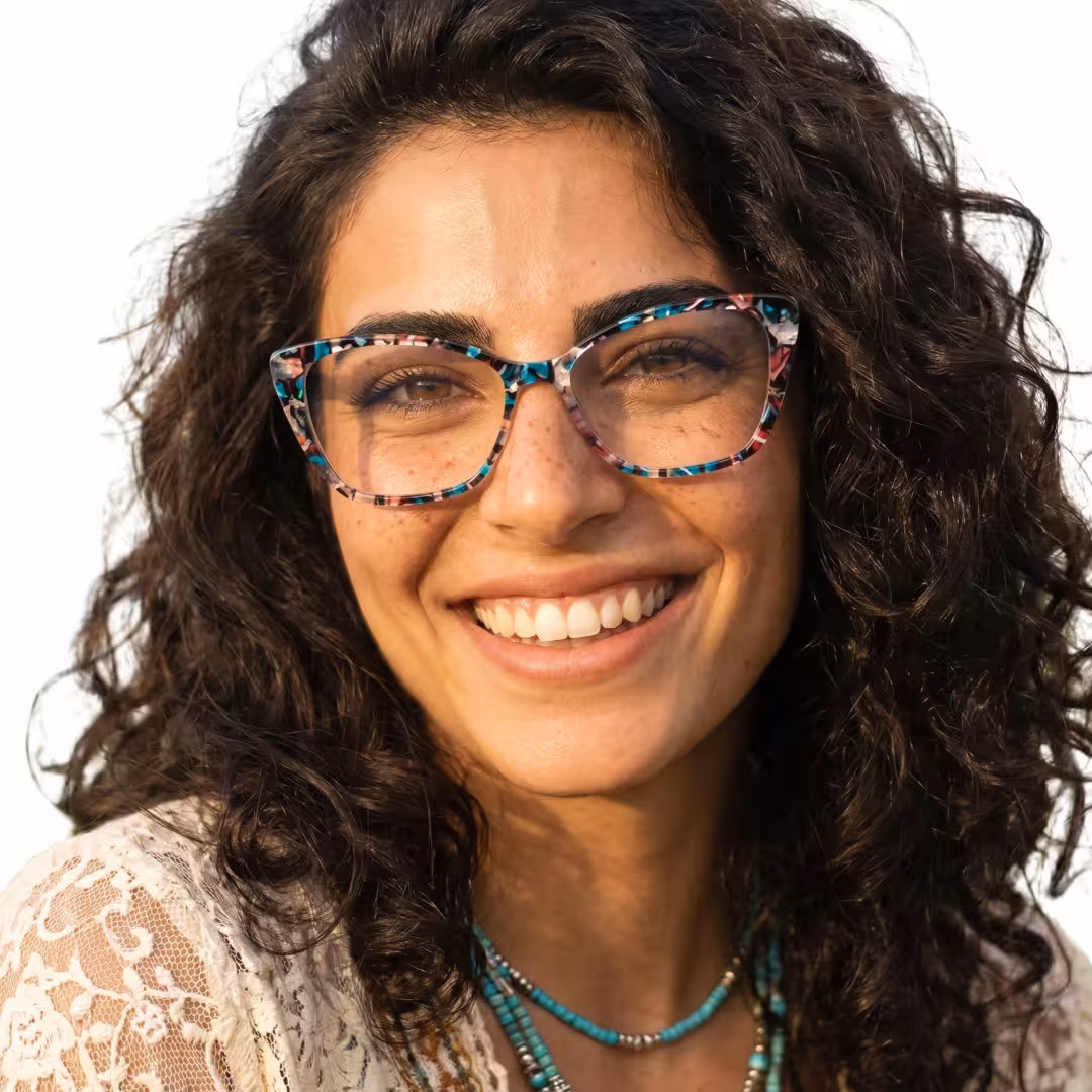 Front view of female wearing colorful blue tortoise cat eye eyeglasses, smiling, CA0092307