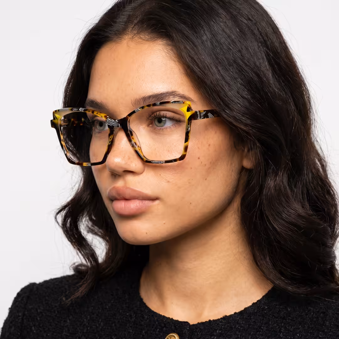 Female wearing colorful tortoise cat eye acetate eyeglasses, maintaining a neutral expression while looking away. SPU: CA0352605