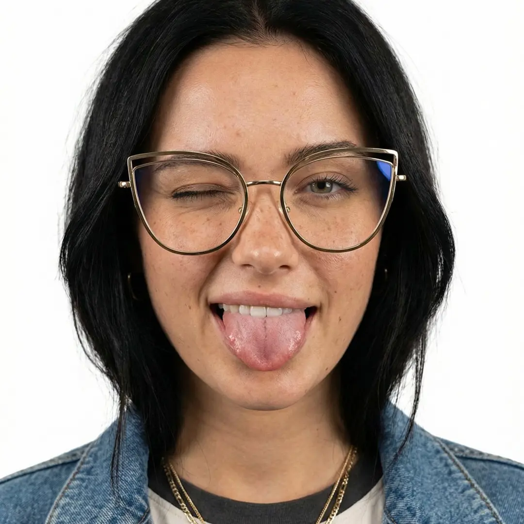Front view of female wearing gold cat eye eyeglasses, sticking out tongue, natural expression, CM0042408