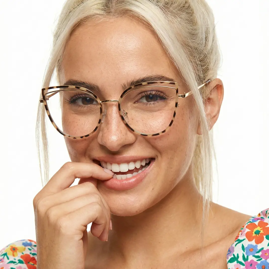 Front view of female wearing tortoise cat eye eyeglasses, smiling, CM0042408