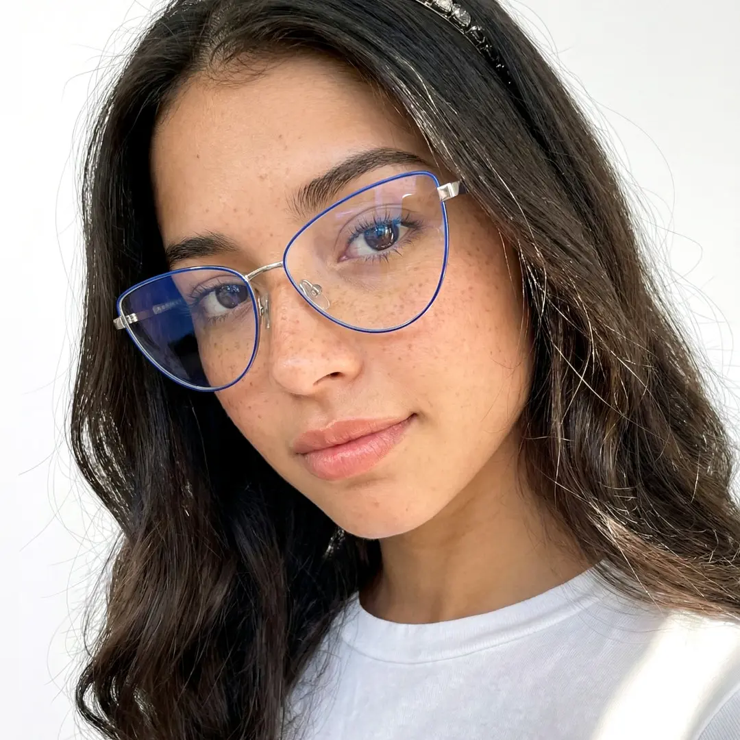 Tilted head view of female wearing blue cat eye eyeglasses, friendly smile, CM0072208