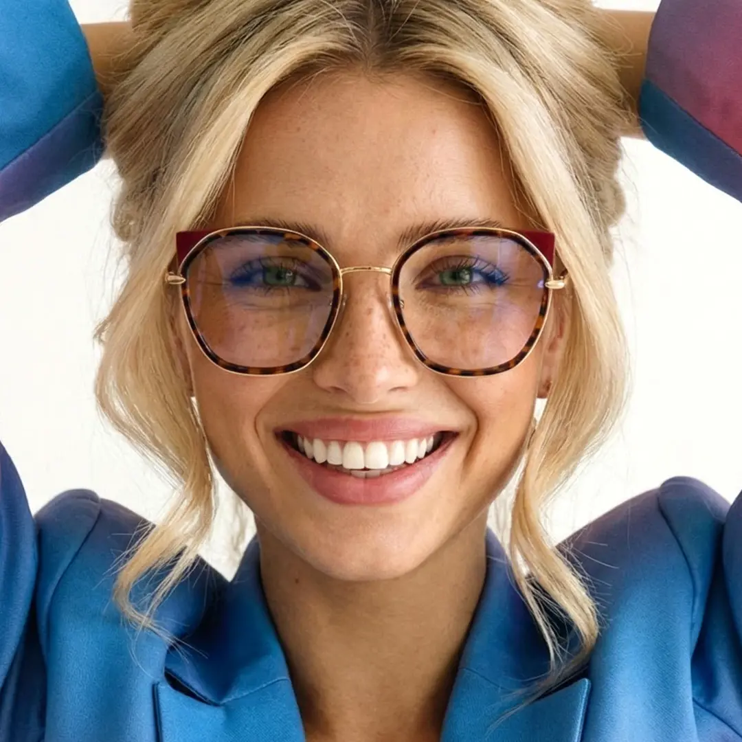 Front view of female wearing tortoise cat eye eyeglasses, smiling, CM0162401
