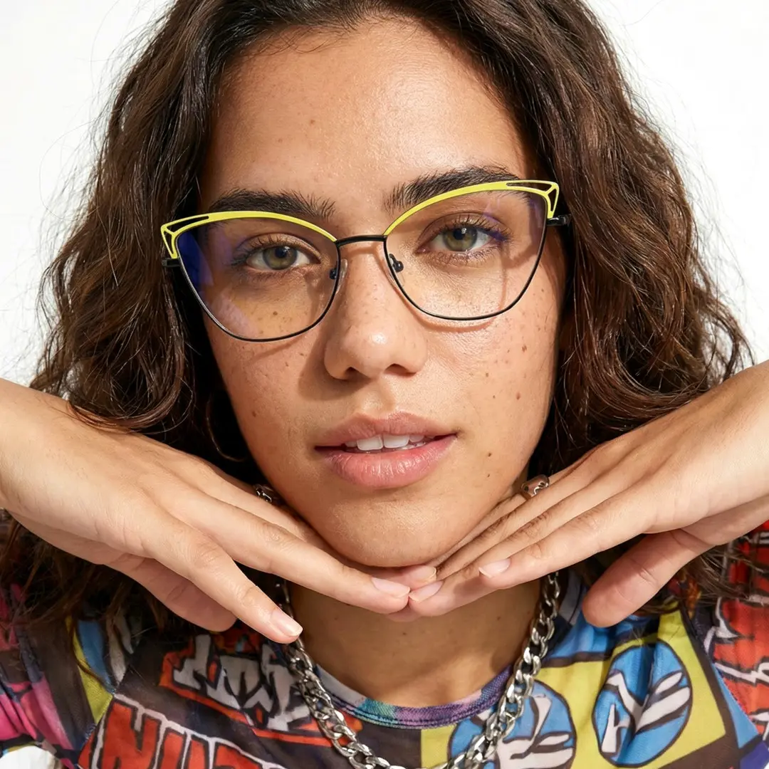 Front view of female wearing yellow cat eye eyeglasses, hand resting on chi, neutral expression, CM0482302