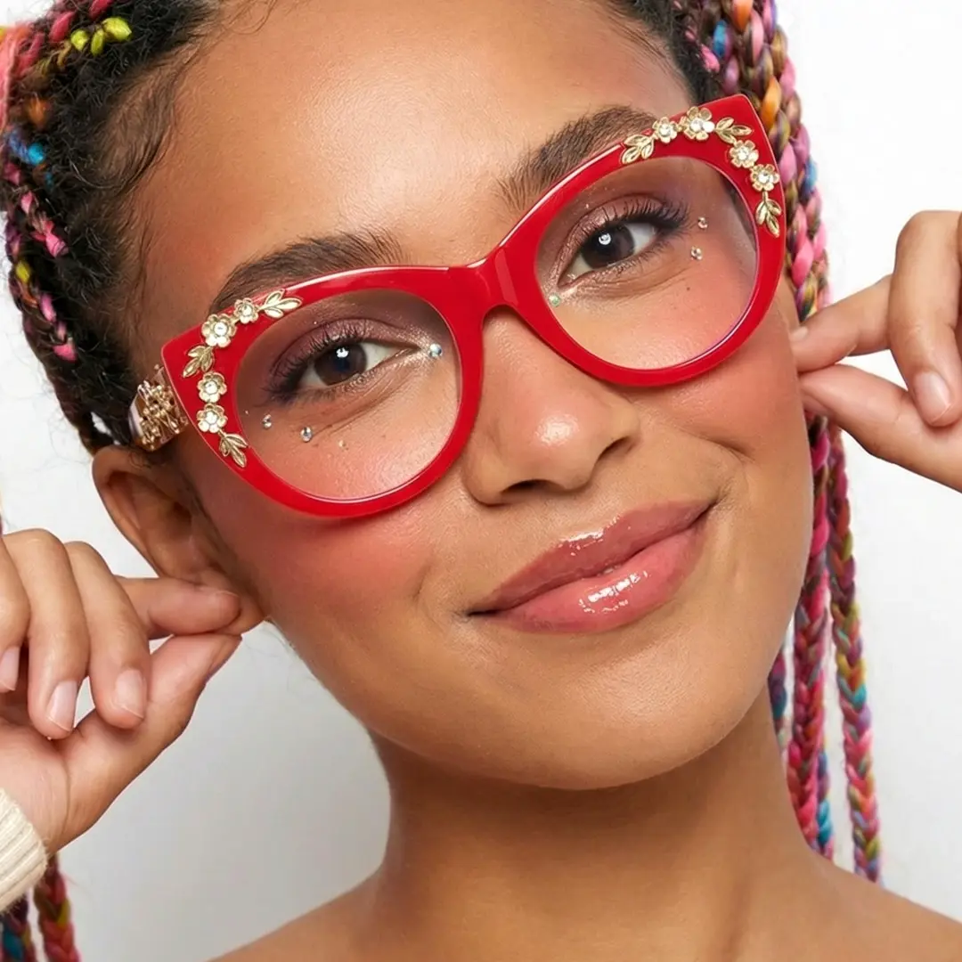 Face close-up view of female wearing red cat eye eyeglasses, hand near face, natural smile, CP0012407