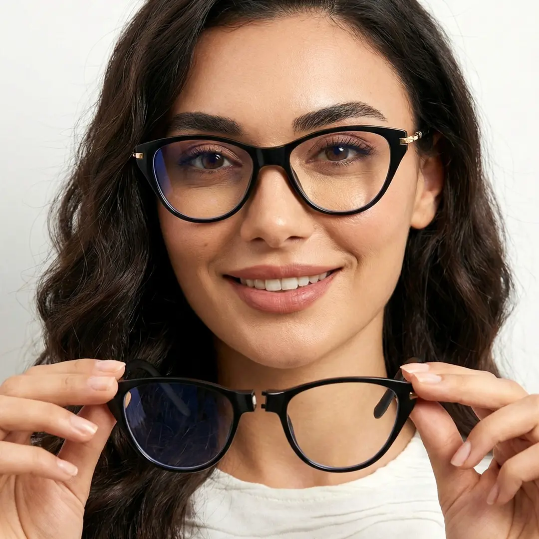 Front view of female wearing black cat eye magnetic clip-on eyeglasses, holding glasses, smiling, CP0072512