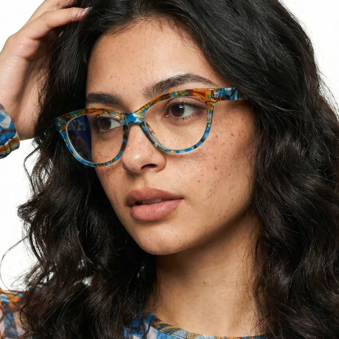 Three-quarter view of female wearing colorful blue cat eye eyeglasses, hand in hair, neutral expression, CP0212303