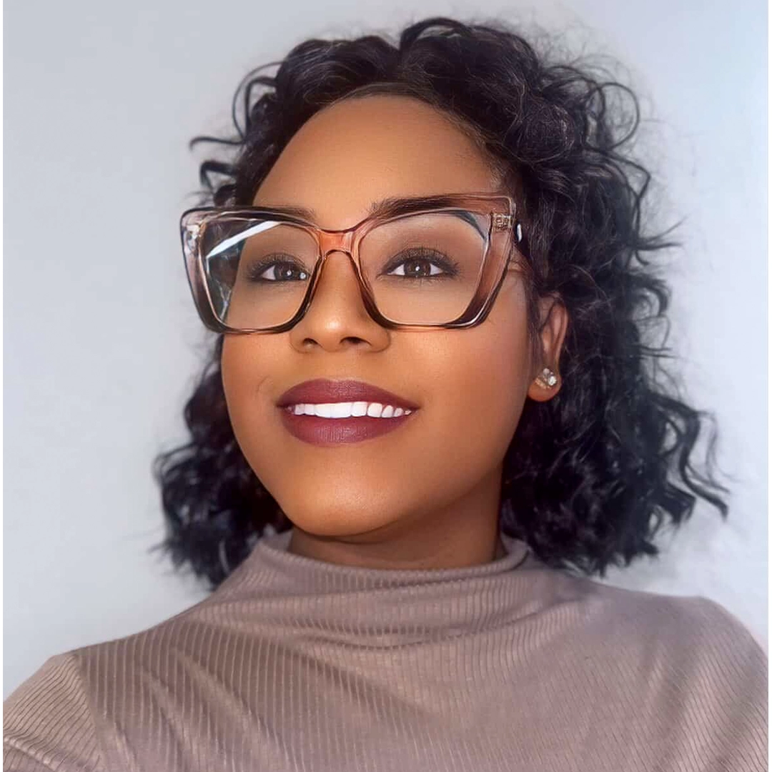 Straight-on view of female wearing pink cat eye eyeglasses, smiling, CP0342506