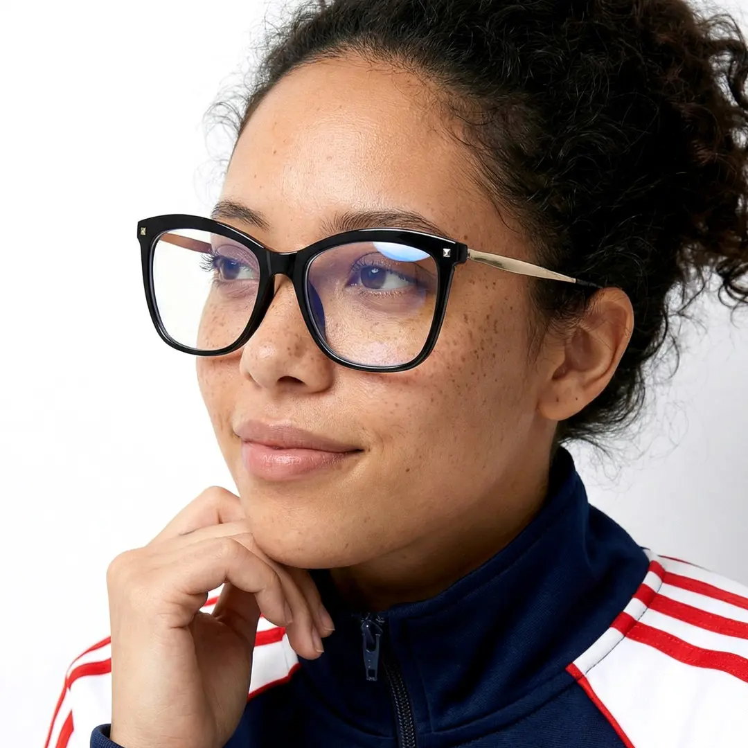Looking away view of female wearing black cat eye eyeglasses, resting chin on hand, natural smile, CP0422504