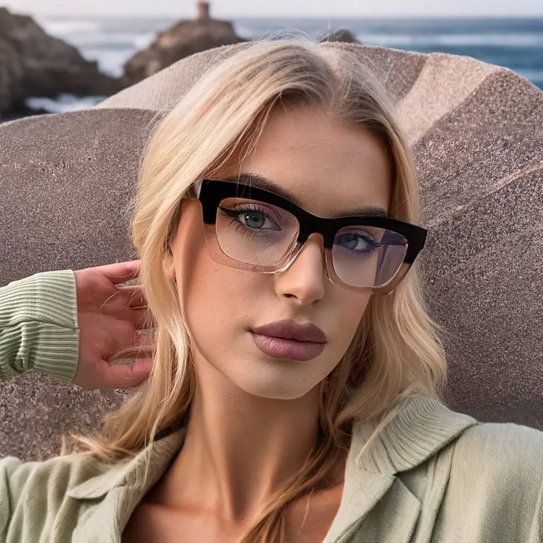 Straight-on view of female wearing black cat eye eyeglasses, hand in hair, calm expression, CR0012209