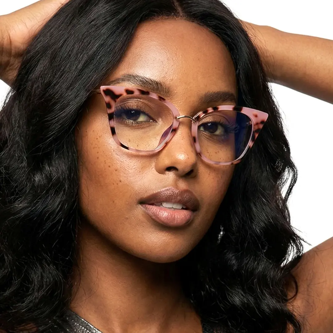 Looking straight ahead view of female wearing red tortoise cat eye eyeglasses, hand in hair, confident expression, CR0012211