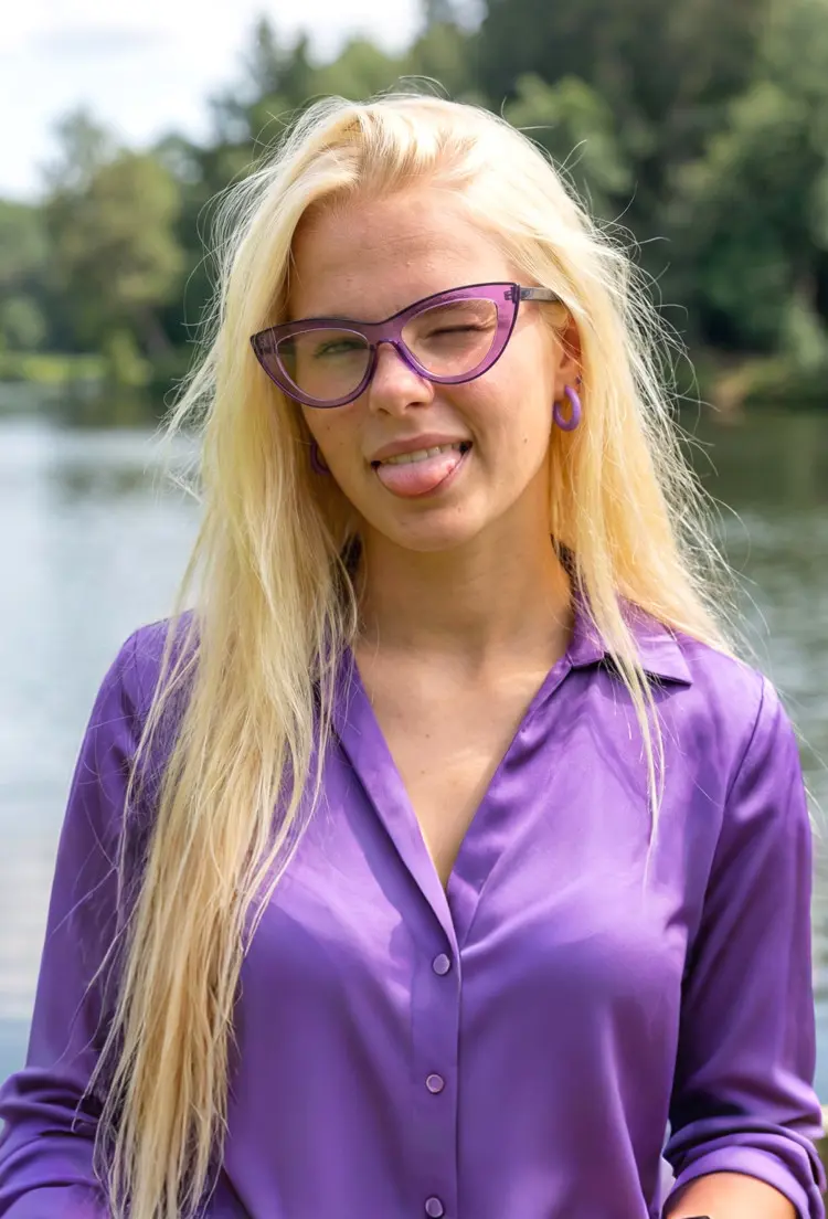 Female model wearing vintage purple cat eye tr90 eyeglasses by a serene lakeside with lush forest trees. SPU: CR0012307