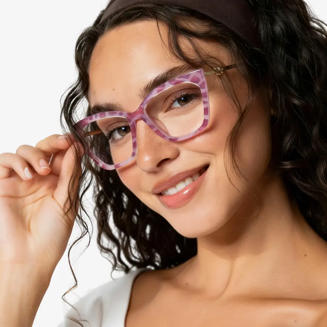 Front view of female wearing pink cat eye eyeglasses, touching frame, natural smile, CR0042310
