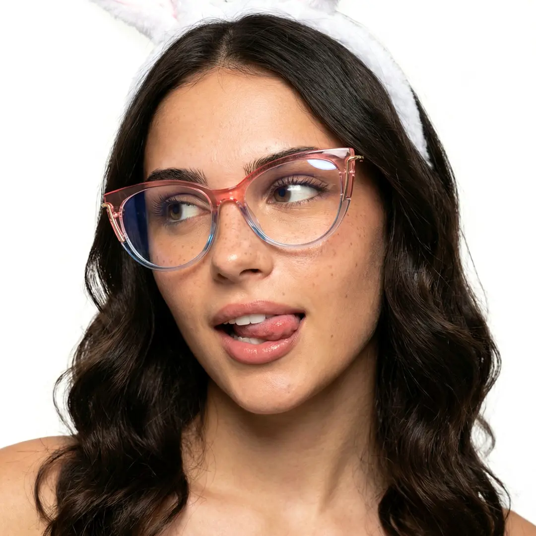 Front view of female wearing pink cat eye eyeglasses, sticking out tongue, soft smile, CR0042402