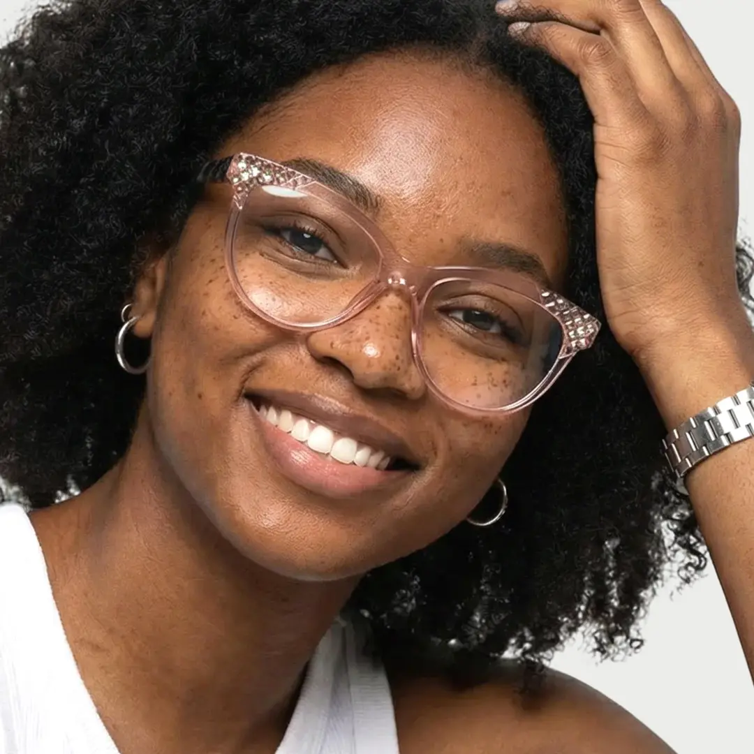 Front view of female wearing light pink cat eye eyeglasses, hand in hair, natural smile, CR0052303