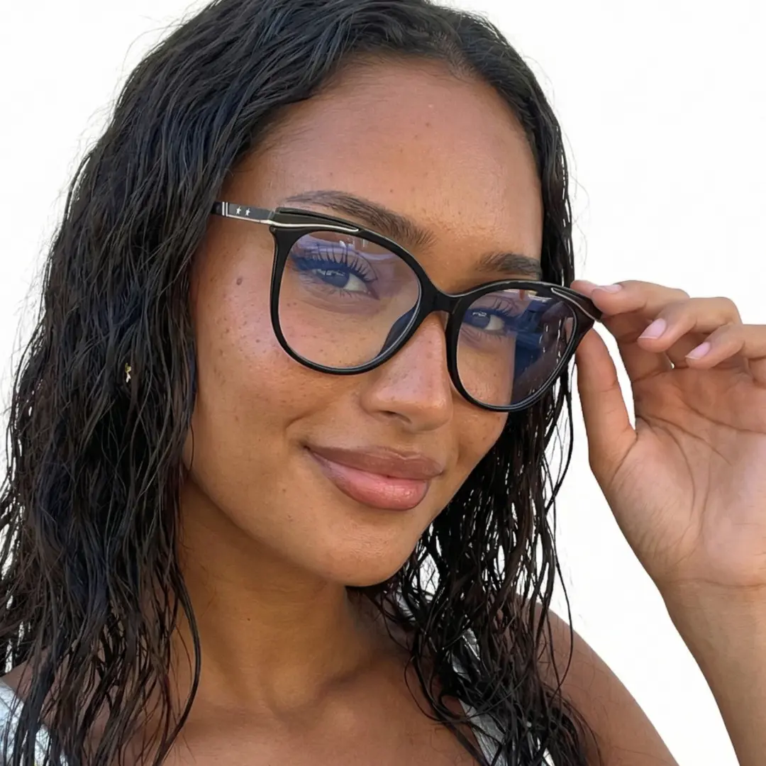 Face close-up view of female wearing black cat eye eyeglasses, holding glasses, soft smile, CR0072408