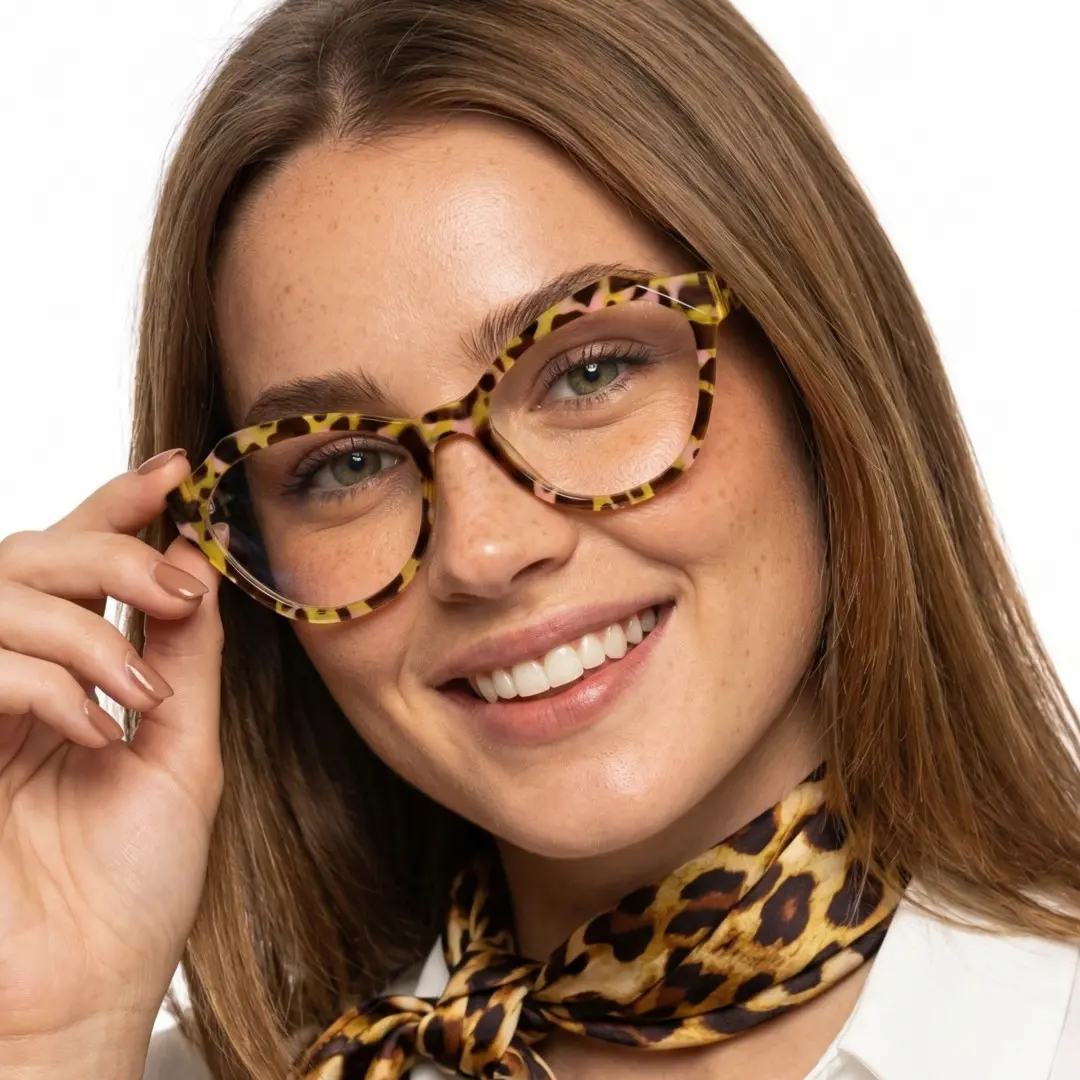Front view of female wearing vintage yellow tortoise cat eye eyeglasses, touching frame, smiling, CR0082411