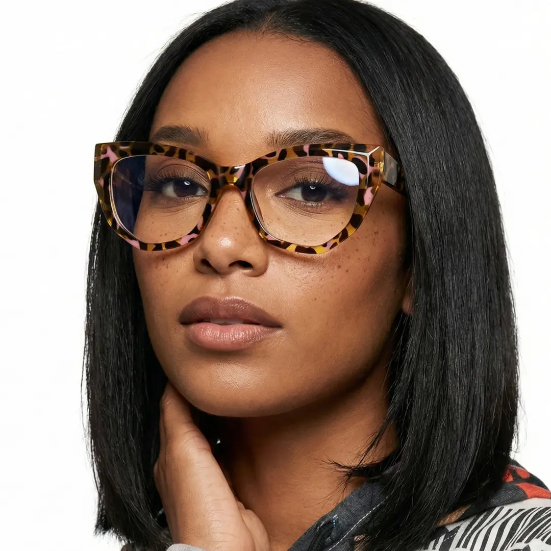 Close-up view of female wearing yellow tortoise cat eye eyeglasses, hand near face, neutral expression, CR0092411