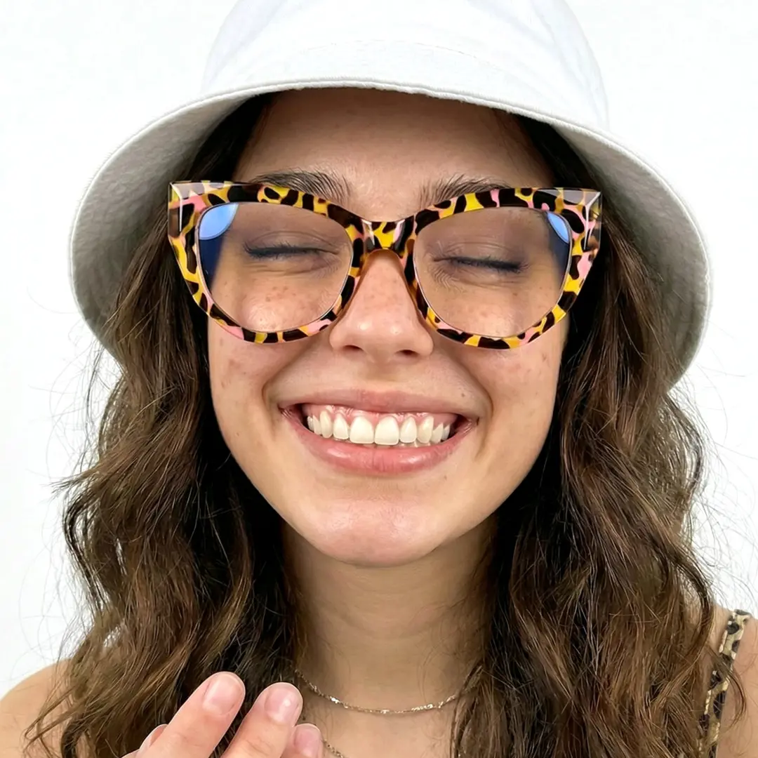 Straight-on view of female wearing yellow tortoise cat eye eyeglasses, friendly smile, CR0092411