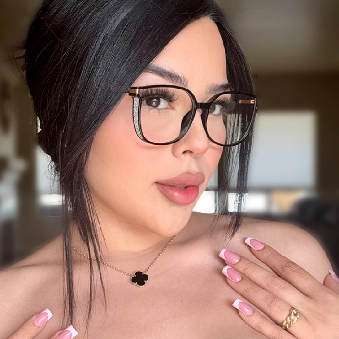 Profile view of female wearing black cat eye eyeglasses, hand touching shoulder, neutral expression, CR0102409