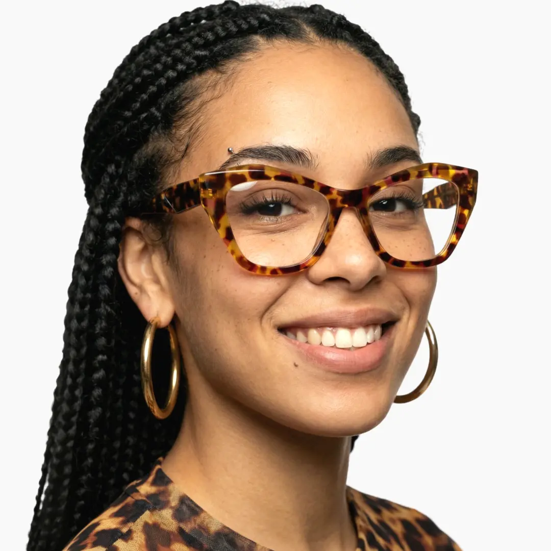 Three-quarter view of female wearing yellow tortoise cat eye eyeglasses, wide smile, CR0102411