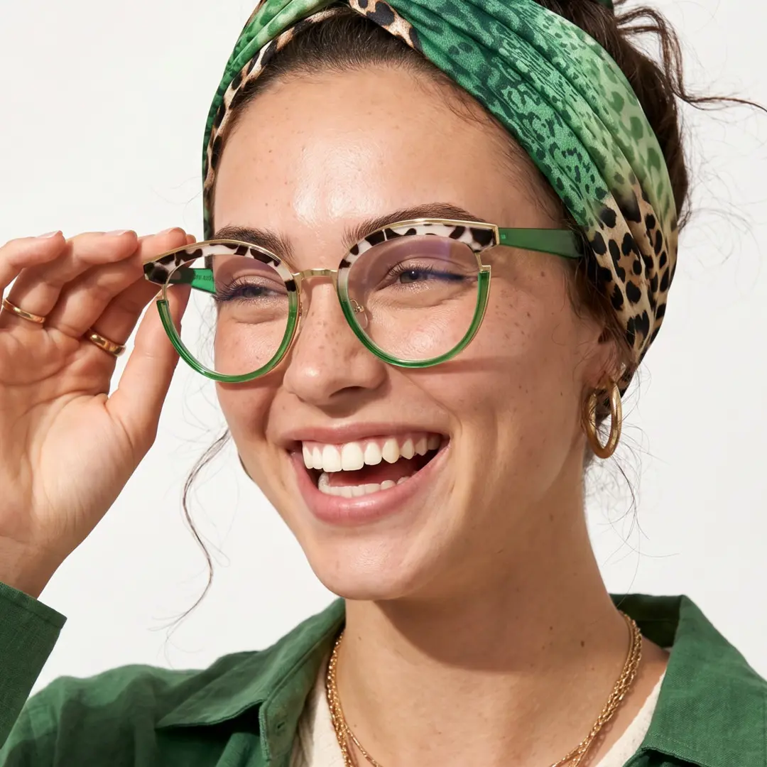 Profile view of female wearing tortoise cat eye eyeglasses, touching frame, big smile, CR0112404
