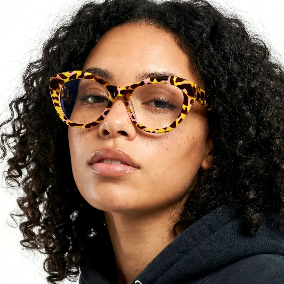 Over-the-shoulder view of female wearing yellow tortoise cat eye eyeglasses, neutral expression, CR0112411