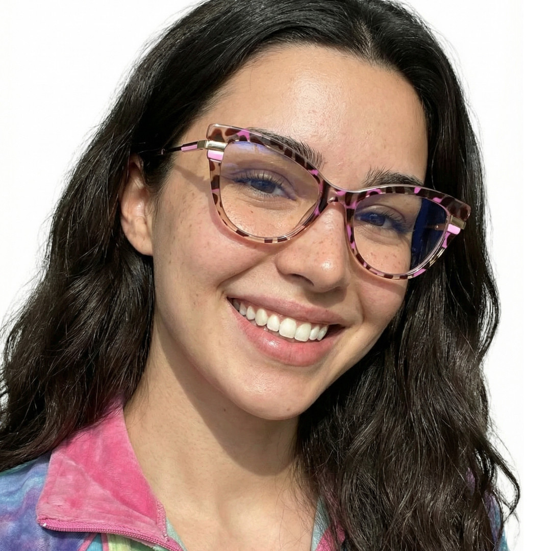 Tilted head view of female wearing red tortoise cat eye eyeglasses, smiling, CR0122411