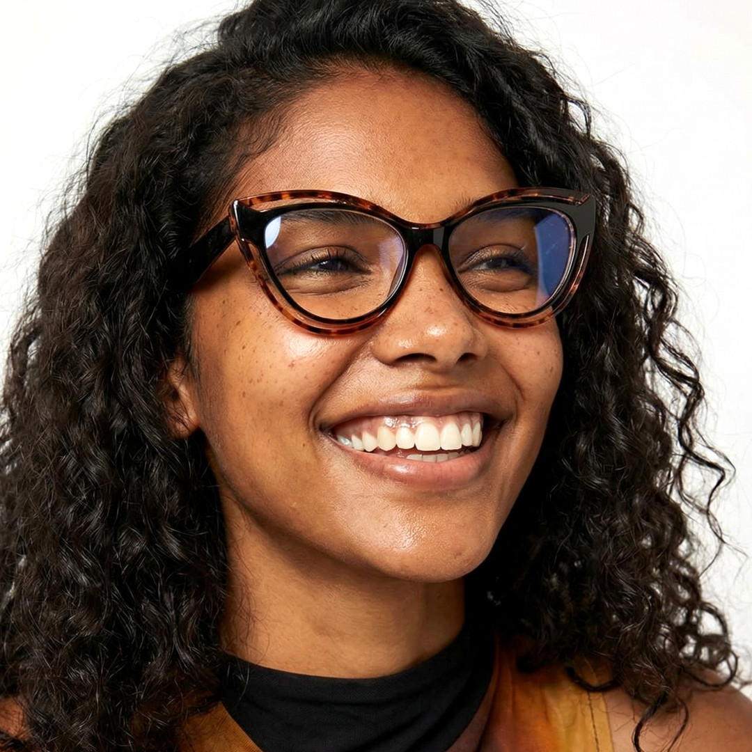 Looking away view of female wearing vintage tortoise cat eye eyeglasses, smiling, CR0132408