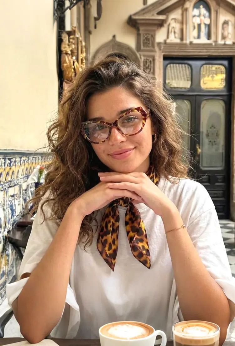 Female model wearing vintage tortoise cat eye tr90 eyeglasses at an outdoor cafe. SPU: CR0132411